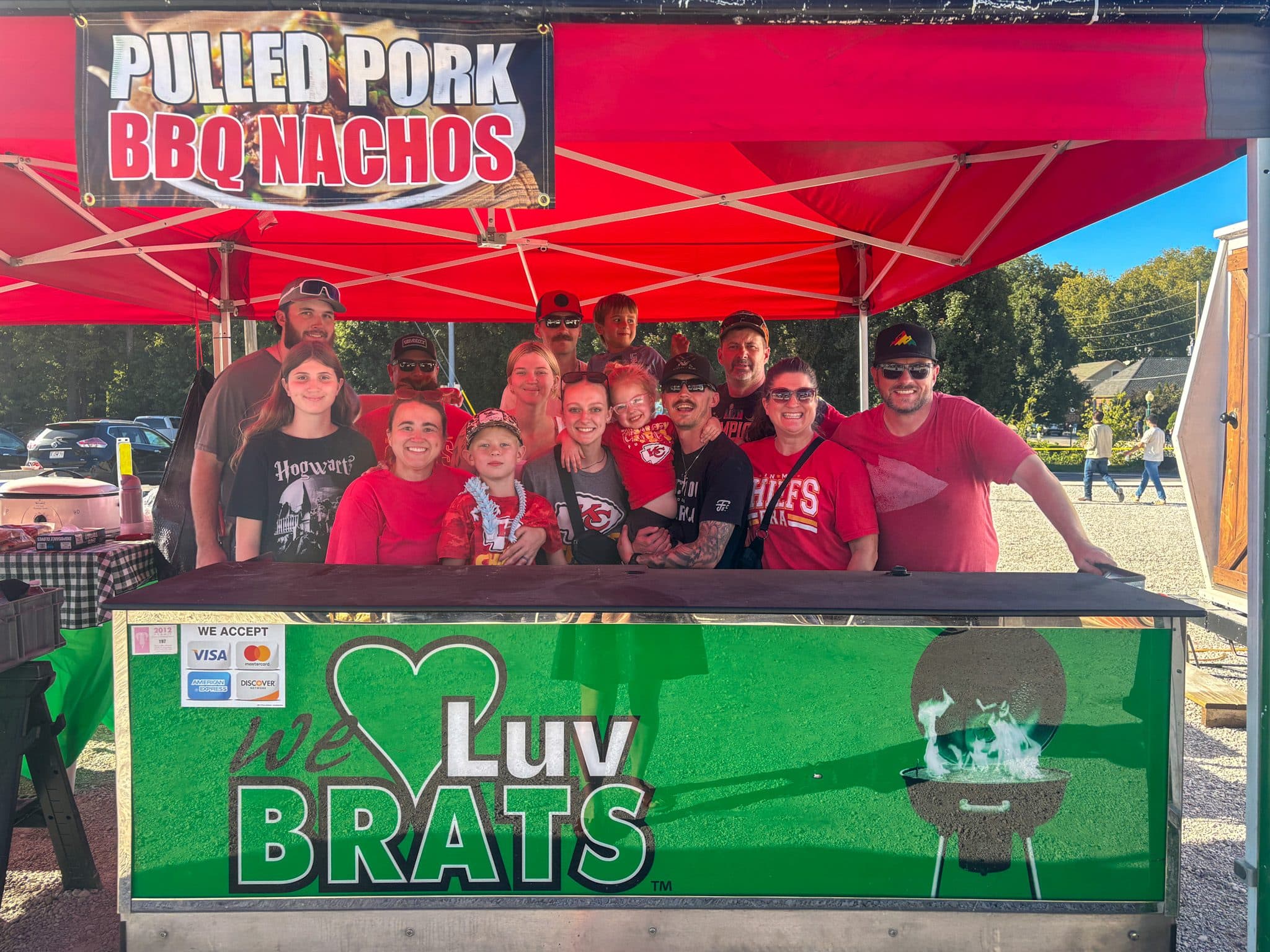 PHOTO BY MEGAN JANTOS
Members of the family behind We Love Brats gather at their Applefest booth. The family has sold food at the festival for more than 15 years to help fund its biennial vacations and reported a single-day sales record this year.