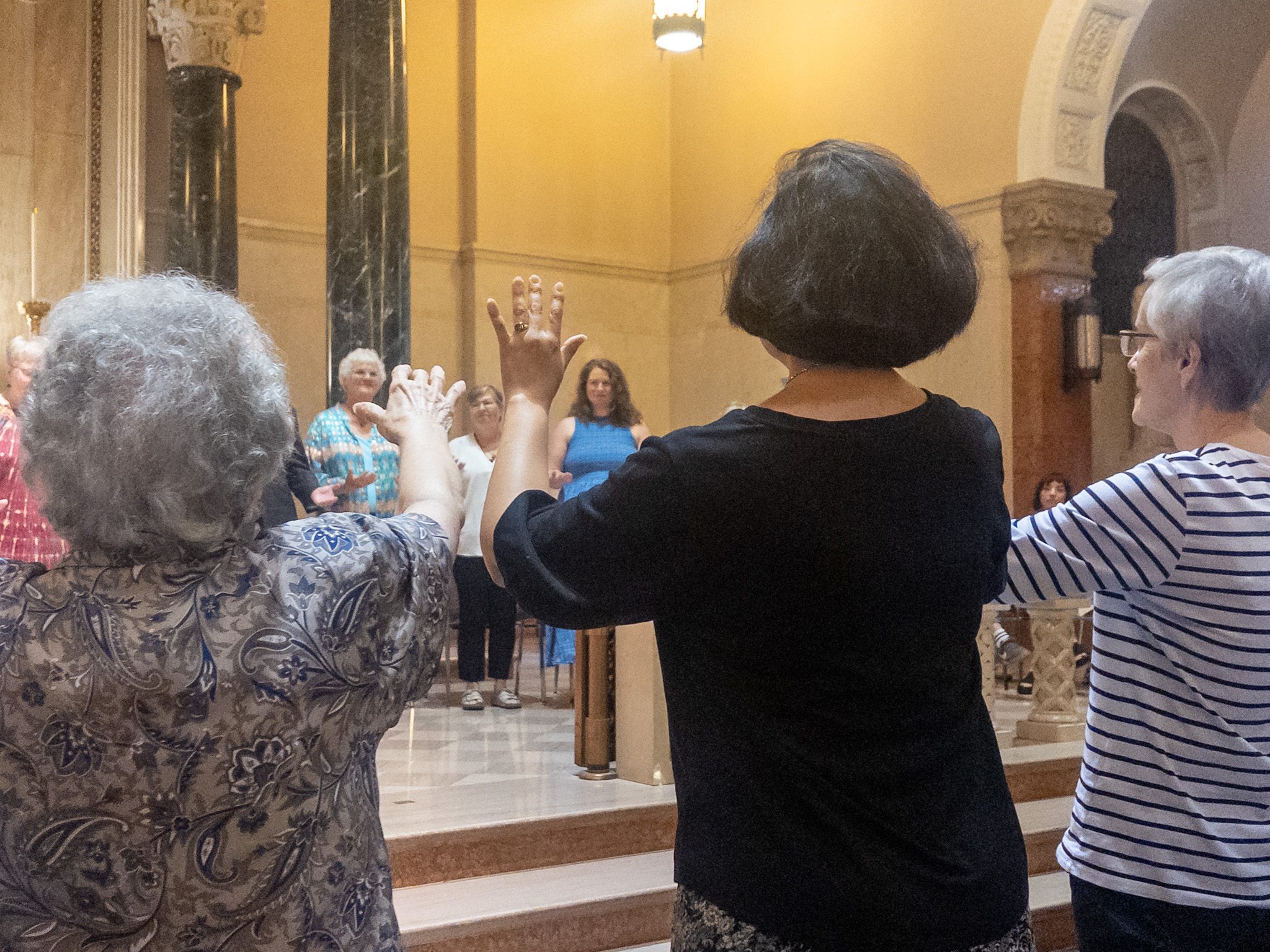 Photo by Megan Jantos
Benedictine sisters raise their hands in blessing over the Rev. Kara Wilson-Tucker and fellow graduates during the Souljourners graduation ceremony July 18 at St. Scholastica Chapel in Atchison, Kan. Wilson-Tucker was among 10 graduates who completed the three-year ecumenical spiritual direction training program sponsored by the Sophia Center at Mount St. Scholastica.